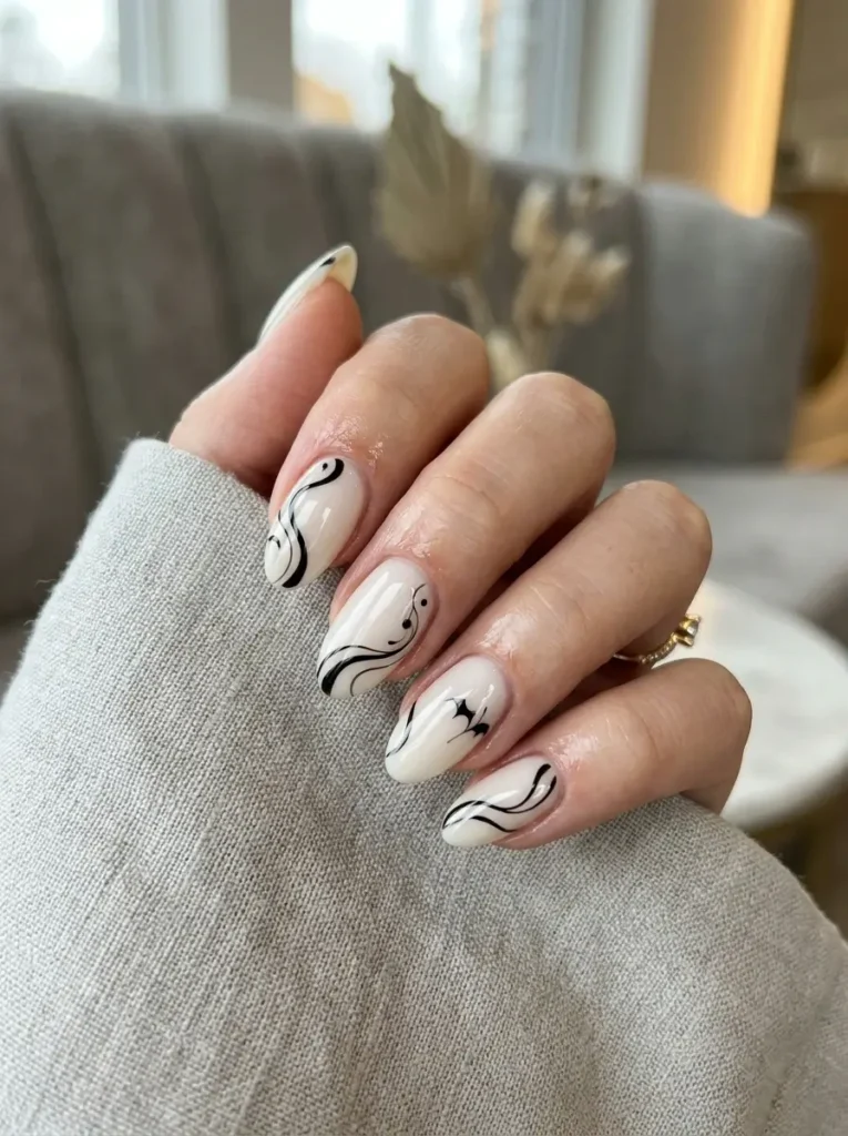 Halloween Nails 2026: 30+ Cute, Classy & Spooky Designs 16 milky white and black swirl Halloween nails